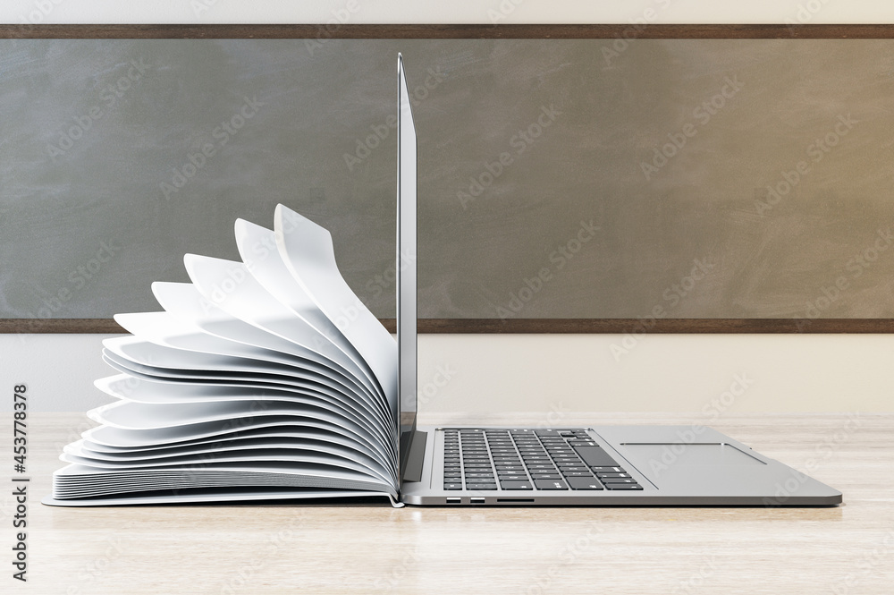 Poster side view of laptop and notepad put back to back on classroom desktop with chalkboard background. on