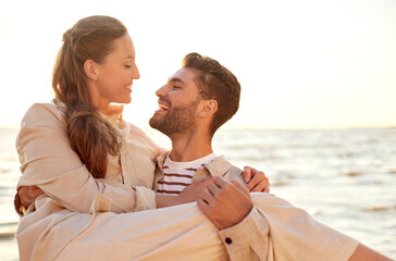 leisure and people concept - happy couple having fun on summer beach
