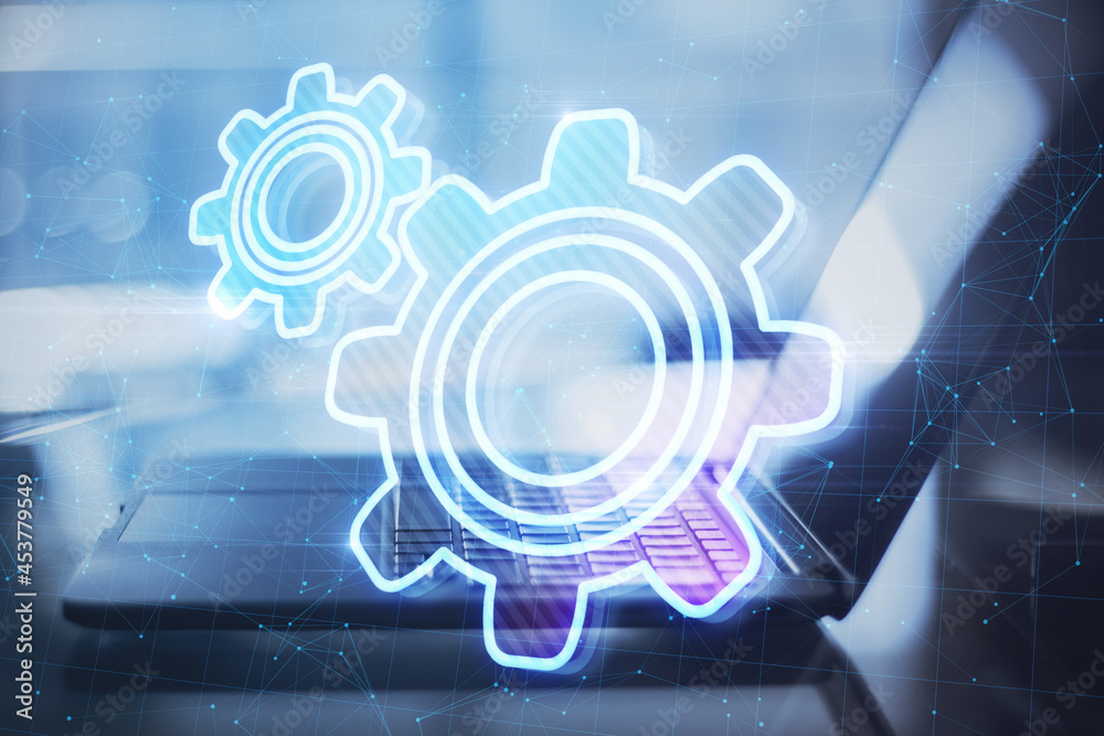 Poster close up of laptop at desktop with abstract glowing gear wheels on blurry background with connection