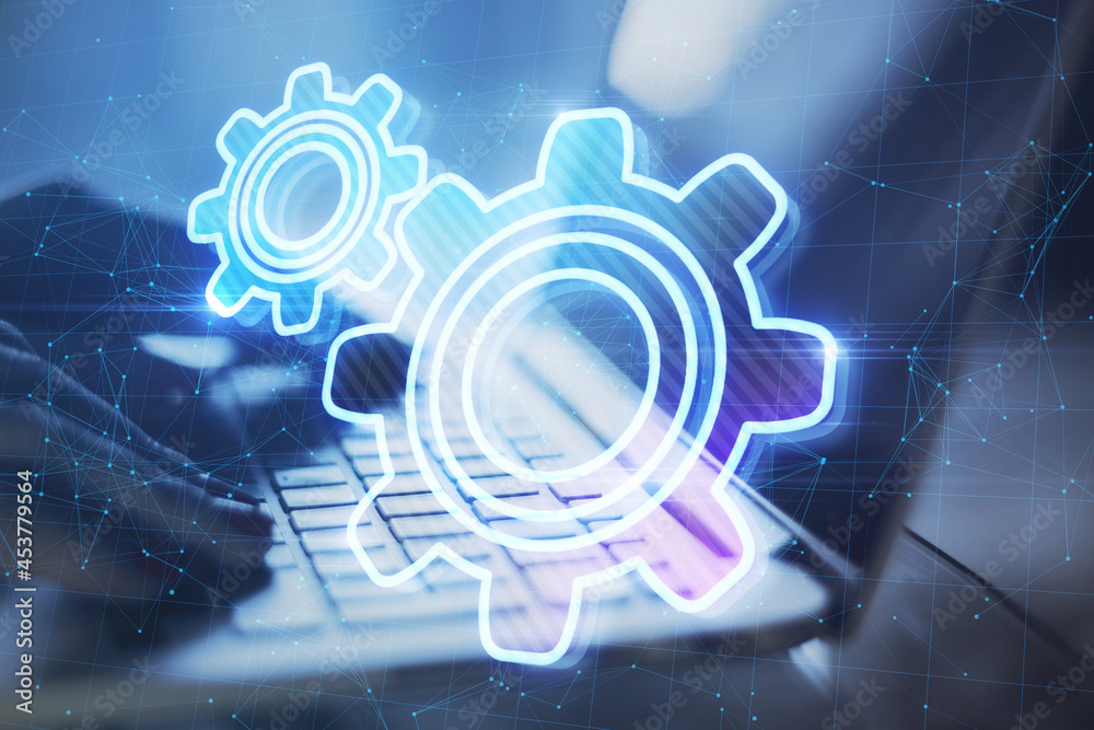 Aufkleber Close up of backlit hands typing on laptop keyboard at desktop with abstract glowing gear wheels on blurry background with connections. Digital engineering and industry concept. Double exposure.