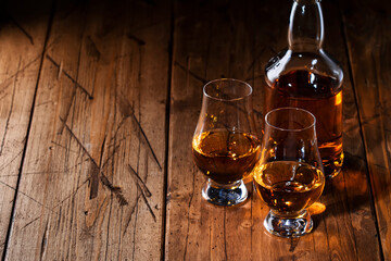 Scotch Whiskey in special glasses and bottle, old wooden background with negative space