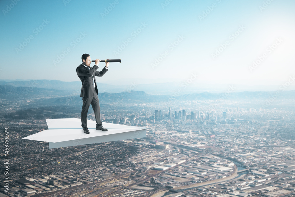 Poster businessman with telescope on abstract paper plane looking into the distance on creative bright sky 