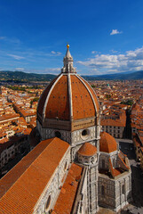 Fototapeta na wymiar Aerial view of wonderful dome of Santa Maria del Fiore (St Mary of the Flower) with tourists at the top and the city of Florence characteristic red tiles. Built by italian architect Brunelleschi in th
