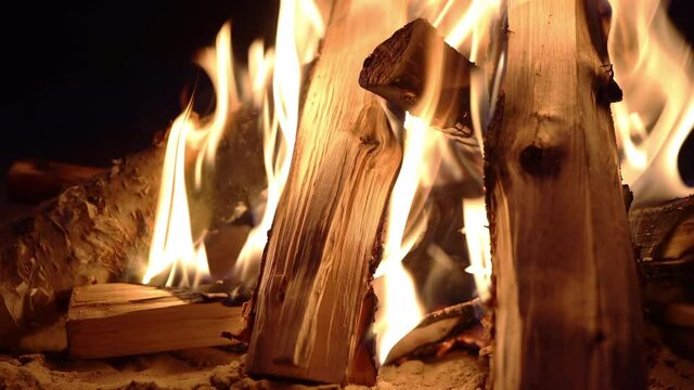 Burning hot firewoods fire sparks on a dark background. Raging Campfire Flames. black background. close up bonfire