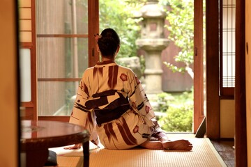 京都町家の和室にたたずむ若い浴衣女性の後ろ姿