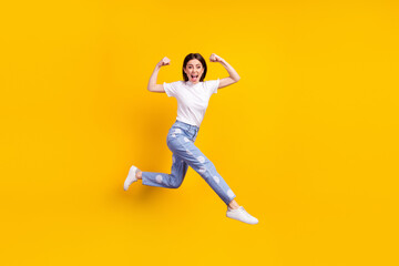 Fototapeta na wymiar Full length profile side photo of young girl happy positive smile jump up go run show muscles isolated over yellow color background