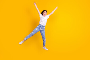 Fototapeta na wymiar Full body photo of young excited girl happy positive smile jump up isolated over yellow color background