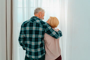 Retired husband and wife hug each other at home
