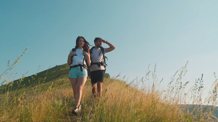 The man and woman hiking with backpacks