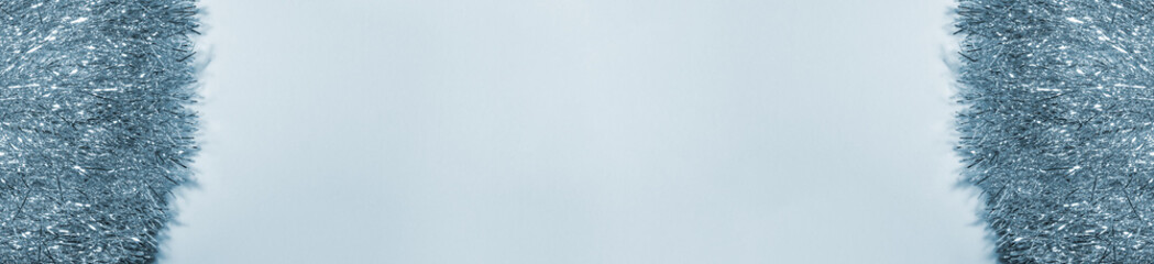 Banner of silver shiny bright garland on blue background on the left and right. Holidays greeting cards and Christmas template concept with copy space.