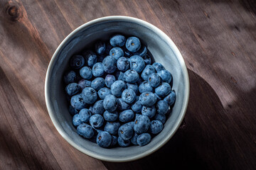 Bol de arándanos sobre mesa de madera