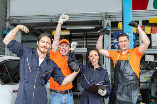 Group of mechanic worker success after worker, service and maintenance in the garage. Diverse male and female technician worker at the automotive spare parts storage warehouse