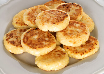 Several fragrant homemade cheesecakes on ceramic dishes, close-up.