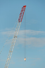 Industrial construction crane against the blue sky. Vertical format.