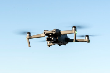 a copter in flight in close-up against the background of a clear blue sky. a device for taking...