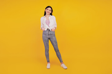 Portrait of charming stunning pretty girl hands pockets posing on yellow background