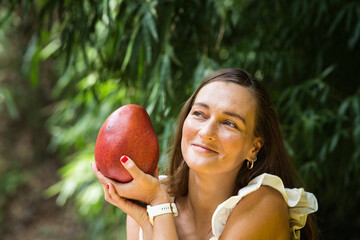 Woman with mango under tree, vegetarian