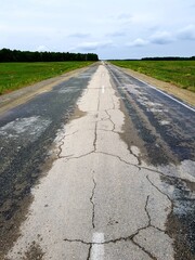 Empty asphalt road in green field
