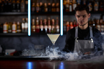 alcoholic cocktail with smoke on the bar table