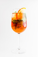 Fruit citrus cocktail in a glass over white background. Delicious alcoholic beverage, sweet drink in a glass.