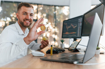 One person in the office. Young businessman in formal clothes is with multiple screens