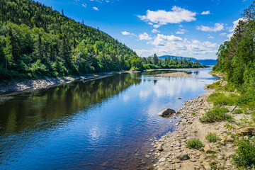 Fototapeta na wymiar Bay Mill, where river meets the Saguenay Fjord, on the Fjord hiking trail near Sacré Coeur, Quebec (Canada)
