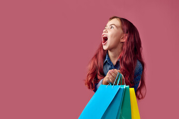 little caucasian child girl holds shopping bags