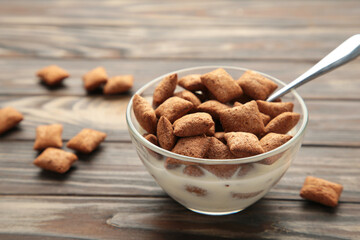 Bowl with chocolate pads on brown background