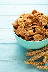Cereal wheat flakes, spikes and rye grain on blue wooden table. Retro toned.