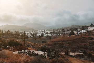 Fototapeta premium Photograph of the town of Haria in Lanzarote among the clouds at sunset.