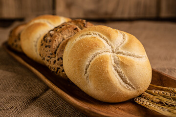 Freshly baked warm buns placed on a wooden bowl.