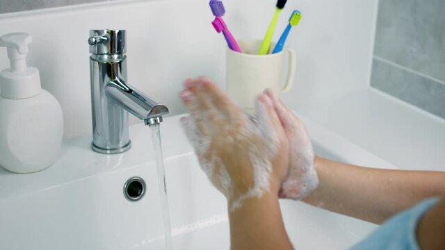A child washes hands with soap, little girl Hands washing to prevention diffusion of virus and bacteria. Healthcare, Basic home hygiene.