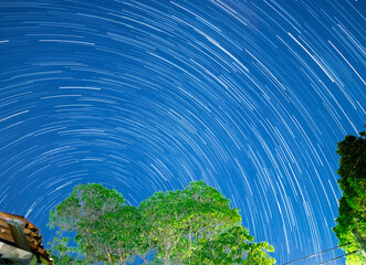 Star trails in a Sydney backyard with house trees and fence in the foreground NSW Australia
