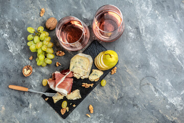 Meat and cheese plate antipasti snack for wine with prosciutto ham, blue cheese, grapes, walnuts and pear. banner, menu, recipe place for text, top view