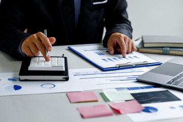 Business man working on project for analyzing company financial report balance statement with documents graphics at modern office. business,economy, market,money and tax concept .