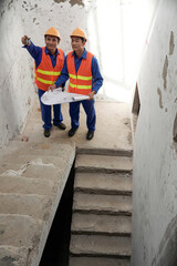 Construction engineers discussing serious problem with staircase unit that was installed wrong