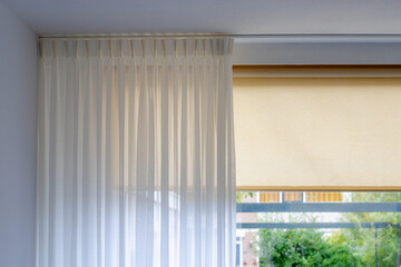 Light and see through concept, Classic white sheer curtains hanging by the window in the room with blurred outside view as background. - obrazy, fototapety, plakaty