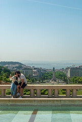 Lisbon, Portugal - May 29, 2021: A couple kissing against the background of the city of Lisbon - Portugal, Vertical, Selective focus