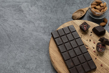 Homemade carob chocolate bar and carob candies on gray background. Healthy food concept.