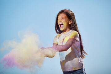 happy little child girl throw bright paints
