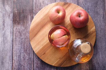 apple vinegar in glass bottle with fresh green apple on table 