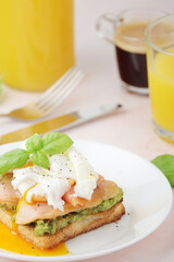 Breakfast with a sandwich with poached egg and avocado