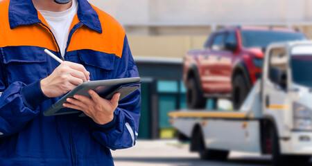 Close up of insurance officer using electronic pen to recording information of broken pickup car on tablet while prepare for transporting to garage after accident on the road © Prapat