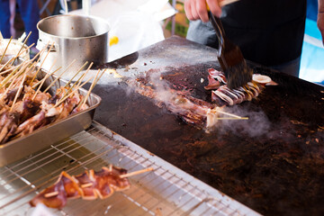 夏祭りの屋台　鉄板で調理されているイカの姿焼き