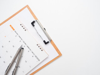 Close up pen on calendar with document board on the table top view isolated copy space