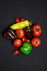 Multicolored farm vegetables on a black background, flat lay
