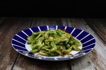 Traditional fried fresh Agasta flower with chilly serving on the plate. Famous vegetarian menu in Asia restaurant. 