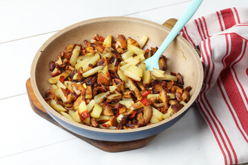 Homemade fried potatoes with chanterelles, garlic and chili pepper