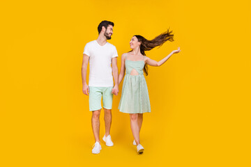 Photo of inspired couple in love hold hands enjoy promenade walk wear casual outfit isolated yellow color background