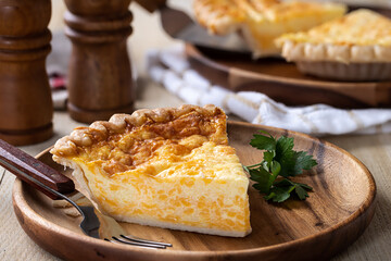 Cheese quiche on a wooden plate